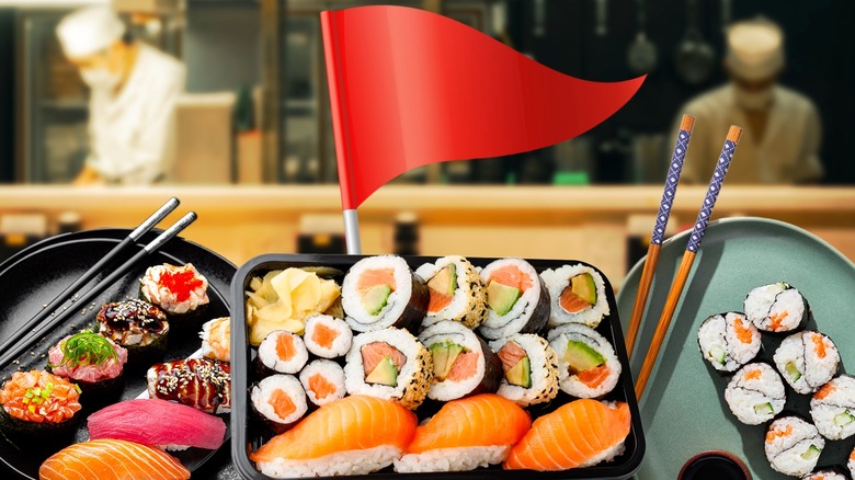 Person holding sushi out with chopsticks, sashimi and sushi in front of them on restaurant table