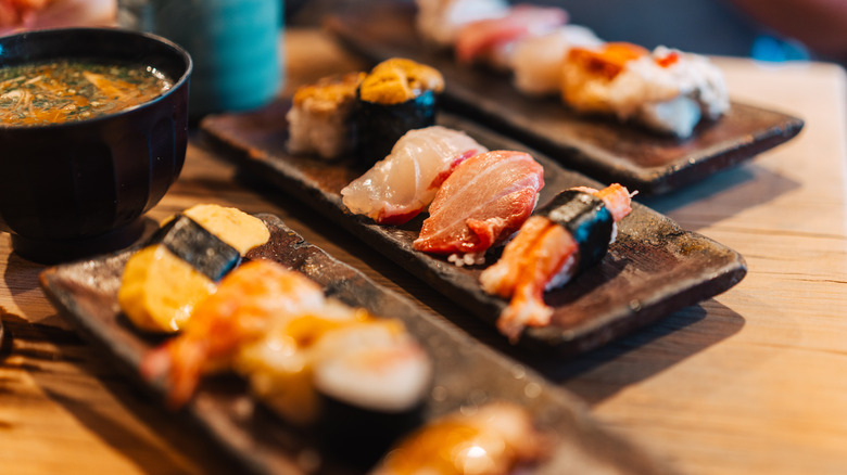 Three trays of assorted sashimi on an omakase restaurant table