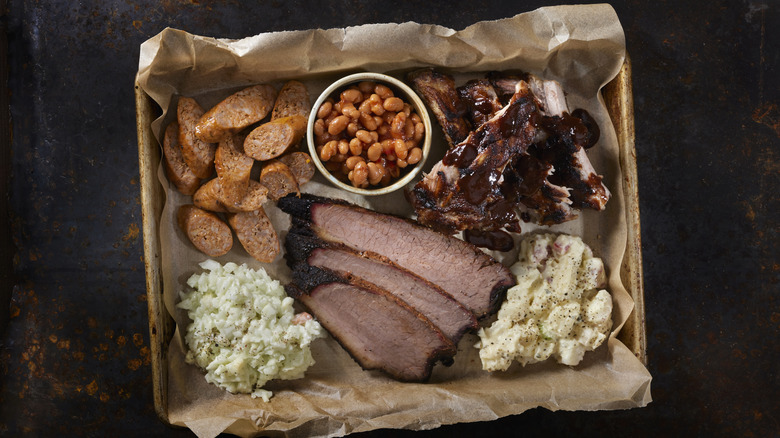 Barbecued meats and sides on a butcher paper-lined metal tray