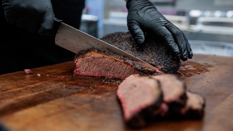 Slicing brisket on a wooden board