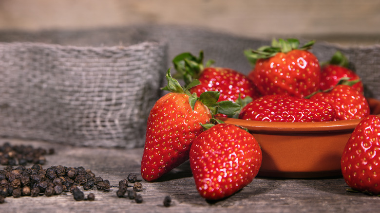 ripe strawberries and black peppercorns