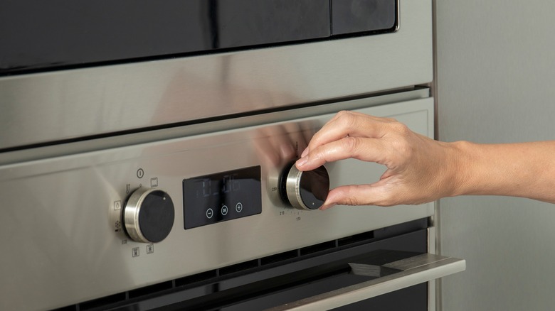 hand adjusting oven temperature