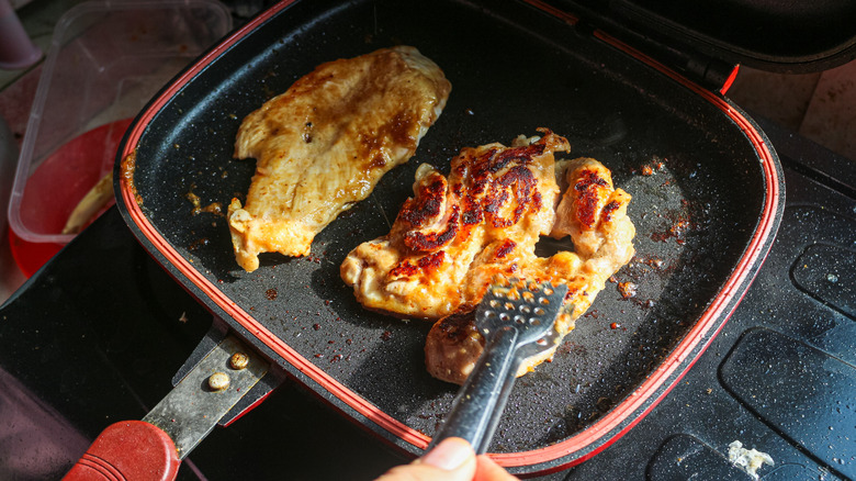 chicken breasts sauteing in pan