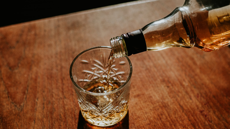 pouring bourbon into glass