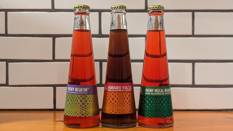 three triangular bottles of red non-alcoholic cocktail