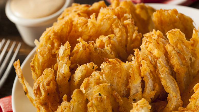 bloomin onion on plate with side of dipping sauce