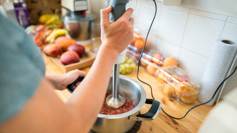 person using immersion blender