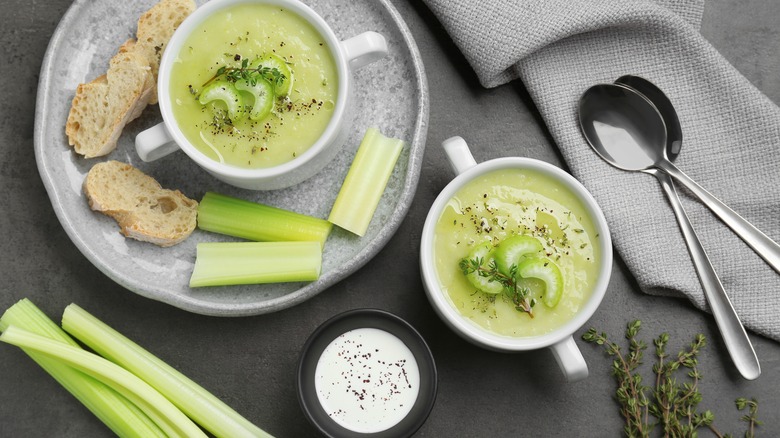 Celery soup served in cups with fresh stalks