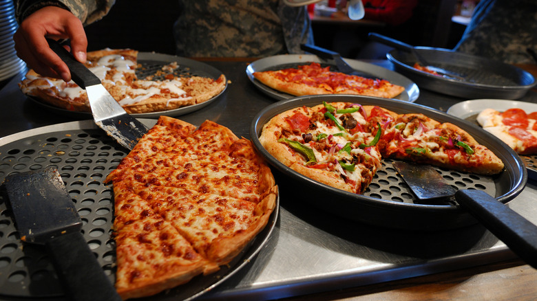 Variety of cut pizzas at a pizza buffet