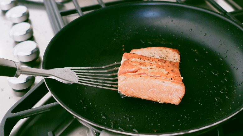 fish being cooked in pan