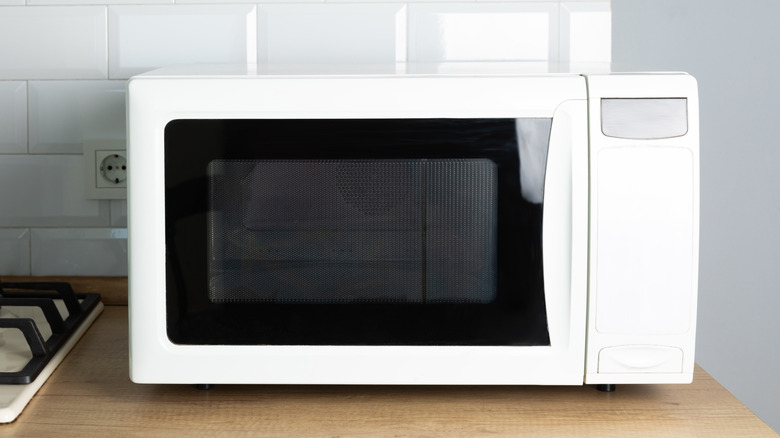 White microwave oven sitting on countertop