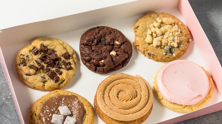 Six Crumbl cookies in a pink box