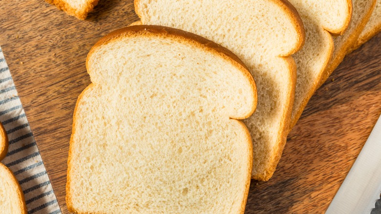 Pieces of white bread on wooden surface