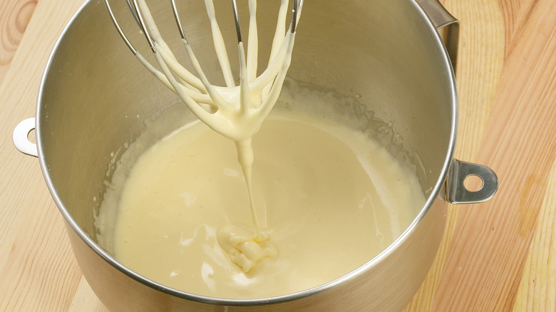 beaten egg yolks and sugar in a bowl with whisk