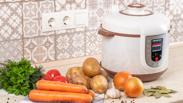 Vegetables on counter with pressure cooker