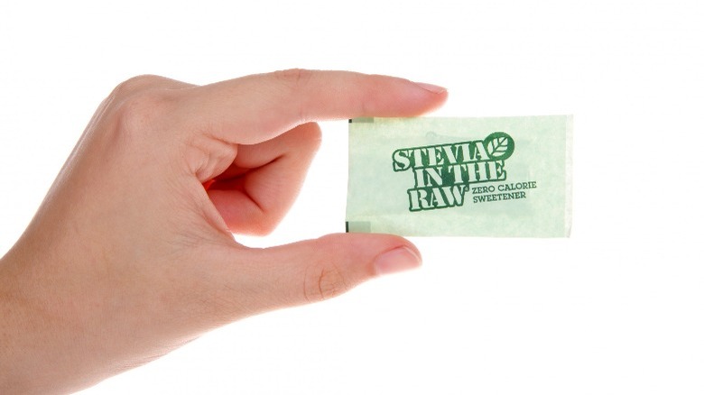 Holding a packet of stevia.