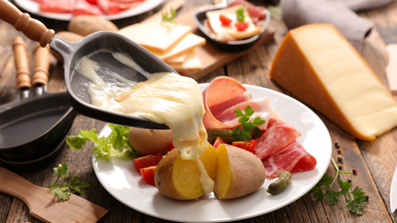 pouring raclette over potatoes