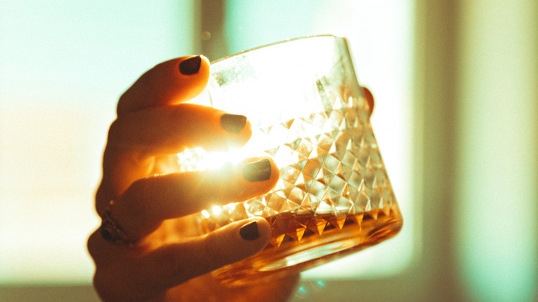 Hand holding whiskey glass