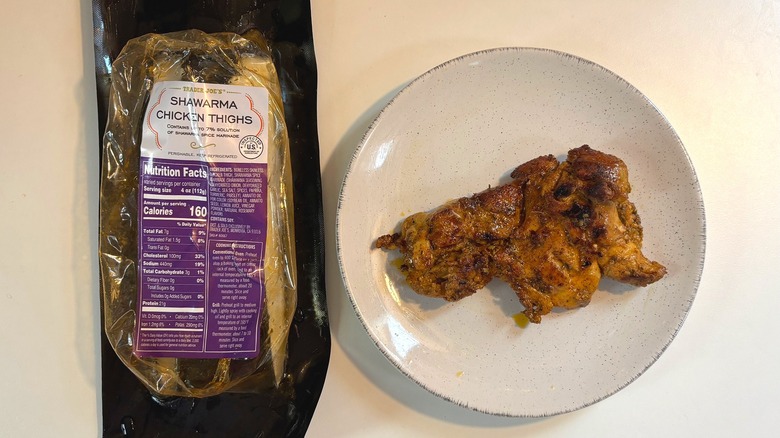 Trader Joe's Shawarma Chicken Thighs package next to plate with chicken thigh on white table