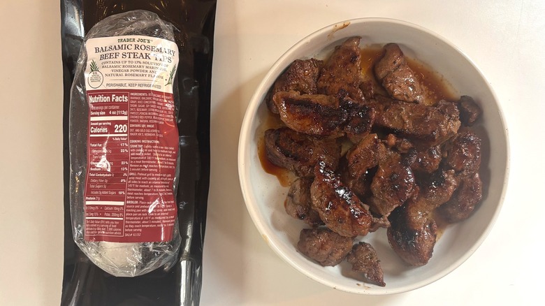 Trader Joe's Balsamic Rosemary Beef Steak Tips package next to bowl of steak tips on white table