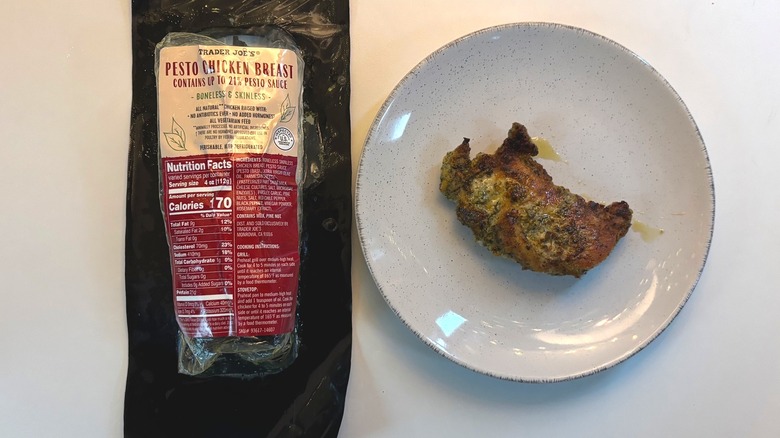 Trader Joe's Pesto Chicken Breast package next to plate of chicken breast on white table