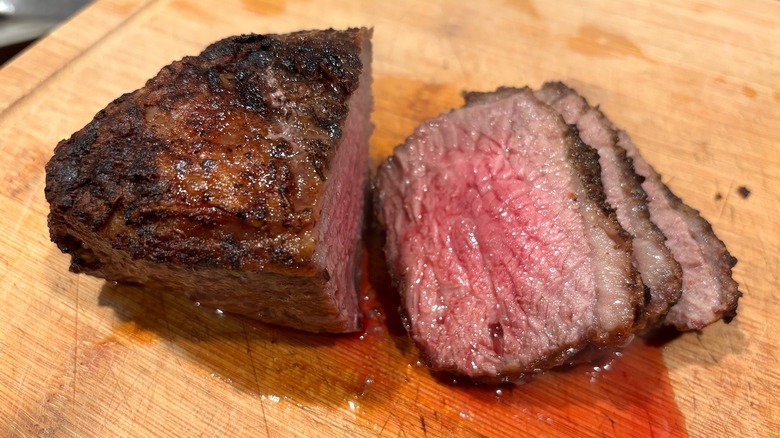 Trader Joe's Santa Maria Tri Tip Roast next to sliced roast pieces on brown cutting board