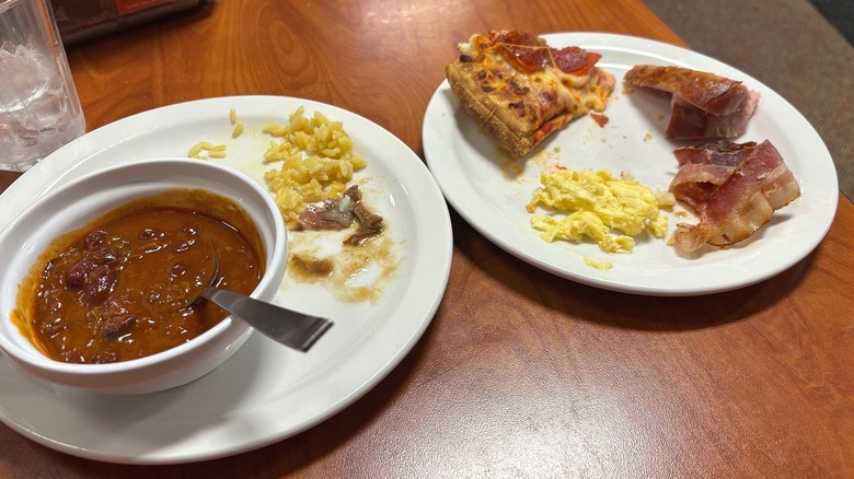 Two white plates with remnants of Golden Corral food on wooden table