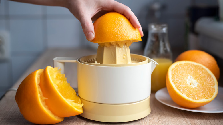 Orange being juiced by hand