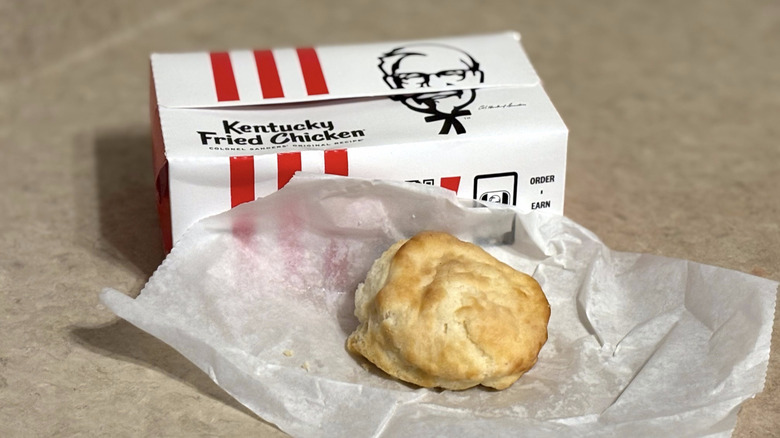 KFC biscuits on white paper with KFC box on neutral counter top