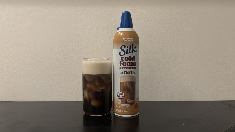 silk oat cold foam can next to iced coffee cup