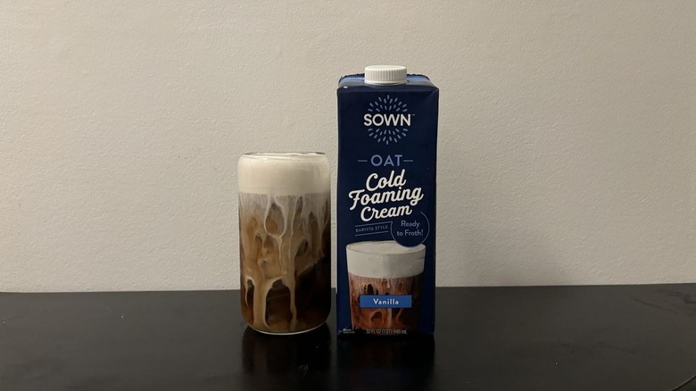 Sown cold foam container next to iced coffee cup