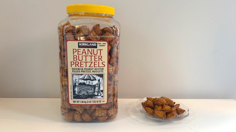 Container of Kirkland peanut butter pretzels next to pretzels on plate