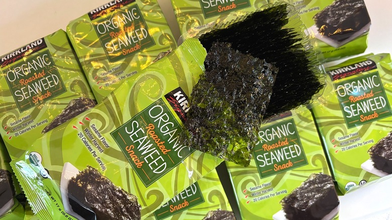 Open package of Kirkland organic roasted seaweed snacks on top of seaweed snack packages on white table