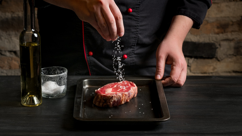 Seasoning steak with salt