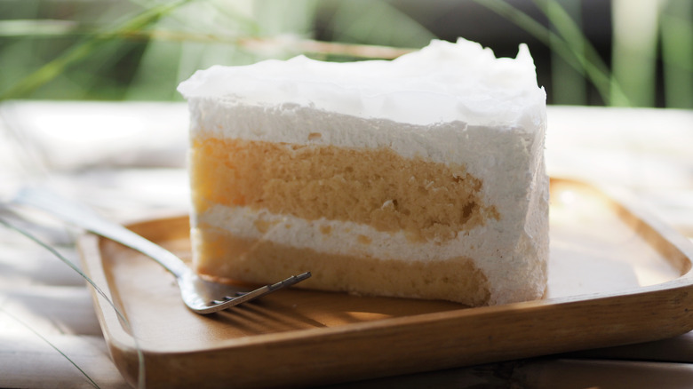 Slice of coconut cake on white plate