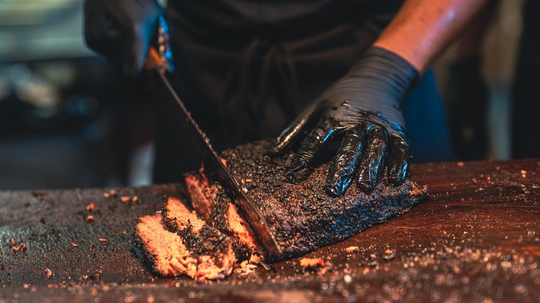 Chef cutting brisket with knife