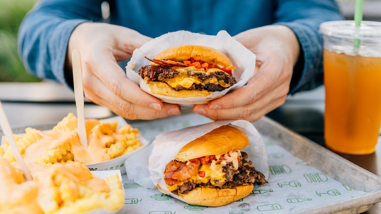 Hands with burger on tray