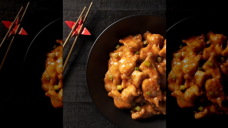Crispy honey chicken from P.F. Chang's in black bowl with chopsticks