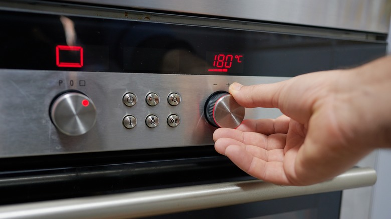 Hand adjusting oven knobs