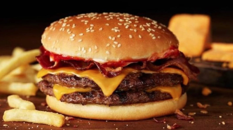 Burger King's Bacon King burger on a wooden cutting board with french fries