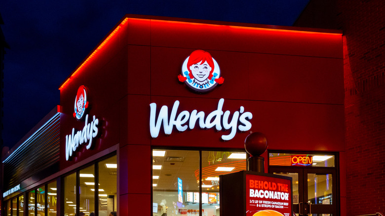 Wendy's sign and building at night with Baconator sign out front