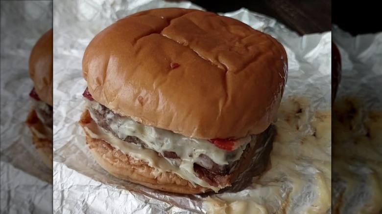 Wendy's Blazin' Baconator burger sitting on foil wrapper