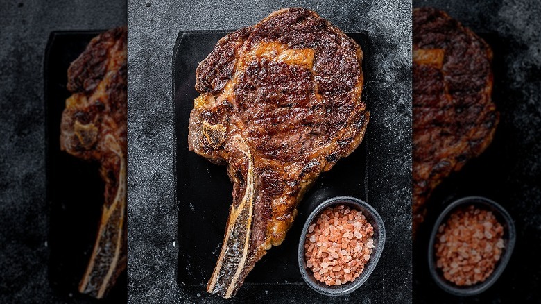 cowboy ribeye on cutting board with salt