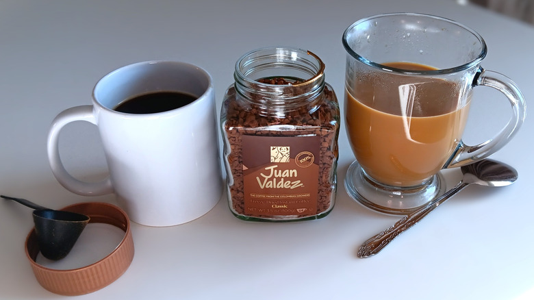 Juan Valdez instant coffee jar with mugs of coffee, black and cream