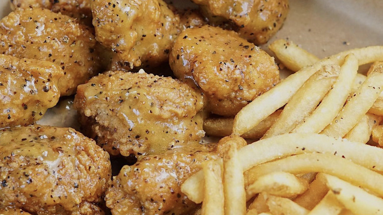 Lemon Pepper sauce on wings with fries 