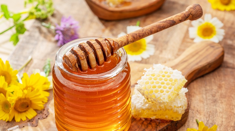 honey in glass jar, honey dipper and honeycombs