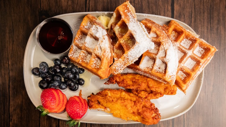 powdered sugar waffles with fried chicken with blueberries and strawberries