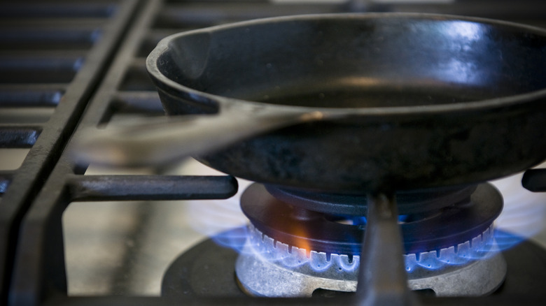 close up of cast iron pan on high heat gas stove