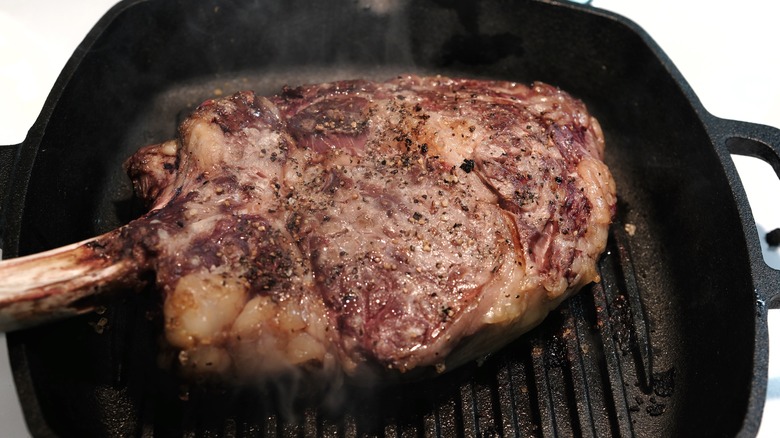 seared tomahawk steak on cast iron