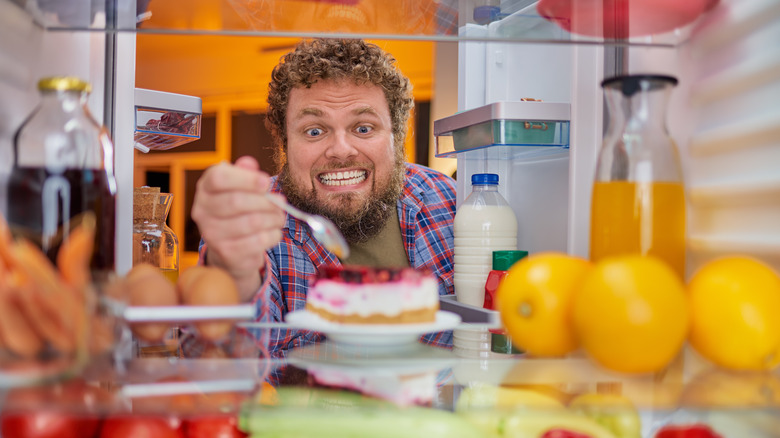 man taking bite of cake